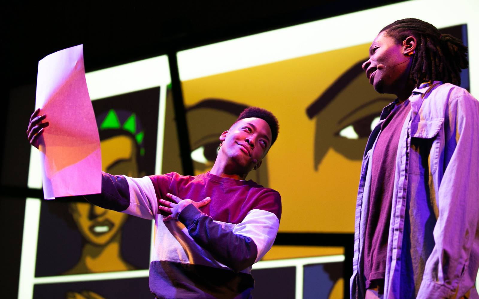 Anderson Stinson, III shows Joshua Robinson a large piece of paper in Black Super Hero Magic Mama.