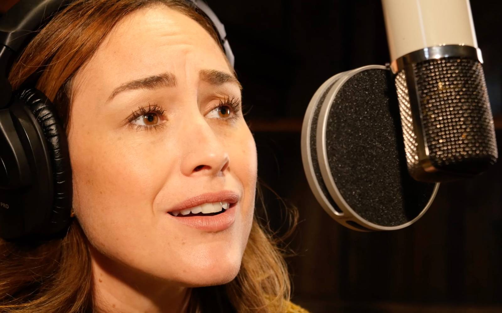 Alison Luff sings into a studio microphone.